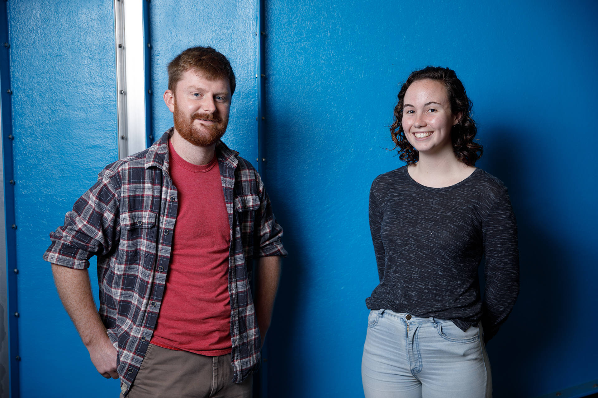 Engineering students stand in front of a blue wall.
